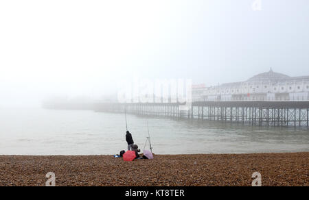 Brighton, UK. 22 Dez, 2017. Ein Fischer können nicht weit auf das Meer sehen von der Palace Pier Brighton an trüben nebligen Tag wie das Wetter ist mild zu bleiben und über die Weihnachtszeit im Süden der britischen Kredit wet: Simon Dack/Alamy leben Nachrichten Stockfoto