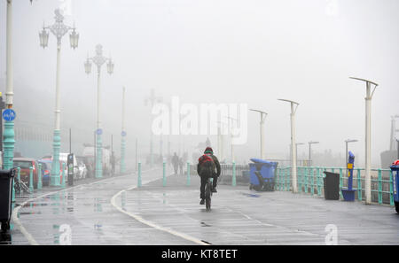 Brighton, UK. 22 Dez, 2017. Ein Radfahrer entlang der Küste von Brighton an trüben nebligen Tag wie das Wetter ist mild zu bleiben und über die Weihnachtszeit im Süden der britischen Kredit wet: Simon Dack/Alamy leben Nachrichten Stockfoto