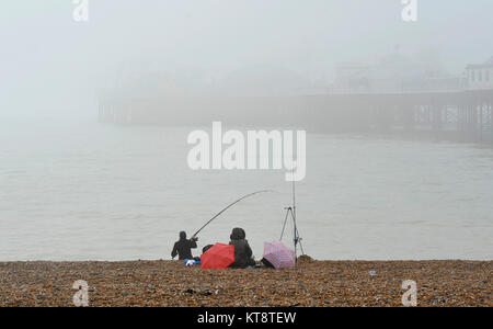 Brighton, UK. 22 Dez, 2017. Ein Fischer können nicht weit auf das Meer sehen von der Palace Pier Brighton an trüben nebligen Tag wie das Wetter ist mild zu bleiben und über die Weihnachtszeit im Süden der britischen Kredit wet: Simon Dack/Alamy leben Nachrichten Stockfoto