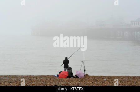 Brighton, UK. 22 Dez, 2017. Ein Fischer können nicht weit auf das Meer sehen von der Palace Pier Brighton an trüben nebligen Tag wie das Wetter ist mild zu bleiben und über die Weihnachtszeit im Süden der britischen Kredit wet: Simon Dack/Alamy leben Nachrichten Stockfoto