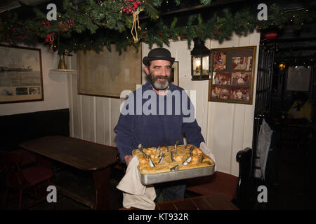 Fowey, Cornwall, UK. 23 Dez, 2017. Tom Bawcocks Eve. Die legendären Tom Bawcock gespeichert das Dorf von Mousehole aus Hunger, indem er Fische in einen schweren Sturm. Während des Festivals eine Stargazy pie gemischter Fisch, Eier und Kartoffel mit Fisch Köpfe und Schwänze aus der Torte kleben. Die Torte ist in der Regel kostenlos in der lokalen Ship Inn serviert. Foto: Simon Maycock/Alamy leben Nachrichten Stockfoto