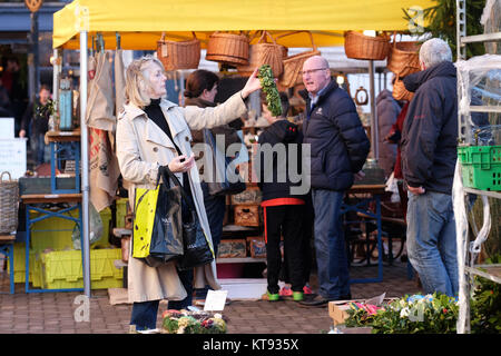 Ludlow, Shropshire, Großbritannien - 23 Dez, 2017. Ein shopper wählt ein Weihnachten Kranz aus dem Markt in Ludlow - Kreditkarten: Steven Mai/Alamy leben Nachrichten Stockfoto