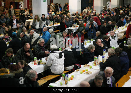 Danzig, Polen. 23 Dez, 2017. Über 500 Menschen nehmen an den Weihnachtsabend Mahlzeit in Danzig, Polen, am 23. Dezember traditionelle polnische Weihnachten Mahlzeit 2017 wurde von christlichen Organisationen organisiert. Personen ein spezielles Wafer beim Austausch von Weihnachtsgrüße. Obdachlosen und Armen wurden mit traditionellen polnischen Bigos, Pierogi, Brot und Kuchen bewirtet. Quelle: Michal Fludra/Alamy leben Nachrichten Stockfoto