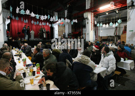 Danzig, Polen. 23 Dez, 2017. Über 500 Menschen nehmen an den Weihnachtsabend Mahlzeit in Danzig, Polen, am 23. Dezember traditionelle polnische Weihnachten Mahlzeit 2017 wurde von christlichen Organisationen organisiert. Personen ein spezielles Wafer beim Austausch von Weihnachtsgrüße. Obdachlosen und Armen wurden mit traditionellen polnischen Bigos, Pierogi, Brot und Kuchen bewirtet. Quelle: Michal Fludra/Alamy leben Nachrichten Stockfoto