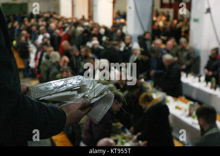 Danzig, Polen. 23 Dez, 2017. Über 500 Menschen nehmen an den Weihnachtsabend Mahlzeit in Danzig, Polen, am 23. Dezember traditionelle polnische Weihnachten Mahlzeit 2017 wurde von christlichen Organisationen organisiert. Personen ein spezielles Wafer beim Austausch von Weihnachtsgrüße. Obdachlosen und Armen wurden mit traditionellen polnischen Bigos, Pierogi, Brot und Kuchen bewirtet. Quelle: Michal Fludra/Alamy leben Nachrichten Stockfoto