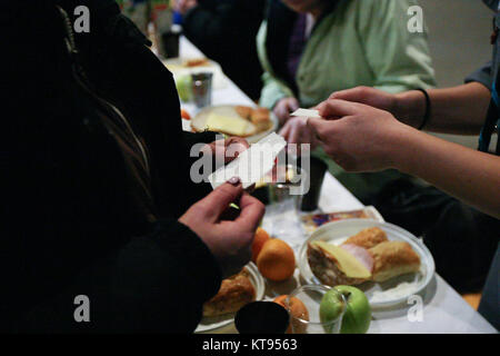 Danzig, Polen. 23 Dez, 2017. Über 500 Menschen nehmen an den Weihnachtsabend Mahlzeit in Danzig, Polen, am 23. Dezember traditionelle polnische Weihnachten Mahlzeit 2017 wurde von christlichen Organisationen organisiert. Personen ein spezielles Wafer beim Austausch von Weihnachtsgrüße. Obdachlosen und Armen wurden mit traditionellen polnischen Bigos, Pierogi, Brot und Kuchen bewirtet. Quelle: Michal Fludra/Alamy leben Nachrichten Stockfoto