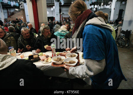 Danzig, Polen. 23 Dez, 2017. Über 500 Menschen nehmen an den Weihnachtsabend Mahlzeit in Danzig, Polen, am 23. Dezember traditionelle polnische Weihnachten Mahlzeit 2017 wurde von christlichen Organisationen organisiert. Personen ein spezielles Wafer beim Austausch von Weihnachtsgrüße. Obdachlosen und Armen wurden mit traditionellen polnischen Bigos, Pierogi, Brot und Kuchen bewirtet. Quelle: Michal Fludra/Alamy leben Nachrichten Stockfoto