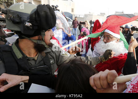 Bethlehem, West Bank. 23 Dez, 2017. Palästinenser verkleidet als Weihnachtsmann konfrontieren die israelische Grenzpolizei während eines Protestes in der West Bank Stadt Bethlehem gegen die Ankündigung der US-Präsident ist Trumpf Jerusalem als Hauptstadt von Israel zu erkennen und die Pläne, die US-Botschaft von Tel Aviv nach Jerusalem zu verlegen. Credit: Wisam Hashlamoun/APA-Images/ZUMA Draht/Alamy leben Nachrichten Stockfoto