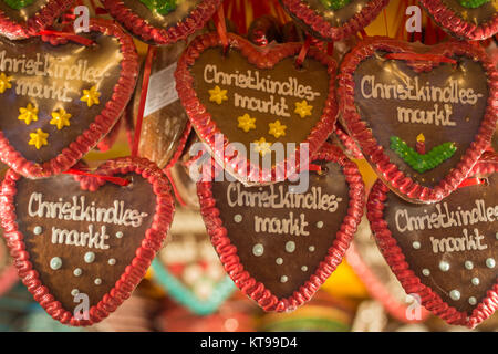 Mehrere Lebkuchenherzen mit Weihnachtsmarkt in deutscher Sprache auf sie mit einem Stand auf dem Weihnachtsmarkt in Nürnberg, Deutschland Stockfoto