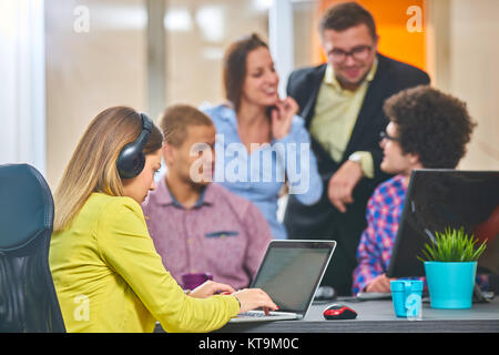 Portrait von Startup Gruppe von kreativen Menschen in einer Sitzung mit einem Laptop in einem modernen Büro. Geschäftsleute in entspannten Gespräch über neue p Stockfoto