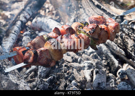 Saftige Scheiben von Fleisch mit Soße vorbereiten auf Feuer Stockfoto