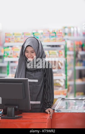 Muslimische Frauen Ladenbesitzer und Kassierer im Supermarkt arbeiten Stockfoto