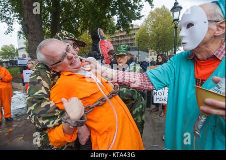 Auf dem 5000 Tag der illegalen Haft Shaker Aamer in Guantanamo, Demonstranten gekleidet, wie Wachen, Gefangenen und Arzt wieder die Kraft verordnen - Fütterung er und andere müssen durch ein Rohr extrem schmerzhaft auf die Nase Zwang unterworfen worden. Stockfoto