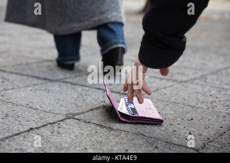 Mann Aufnehmen einer Handtasche verloren Stockfoto