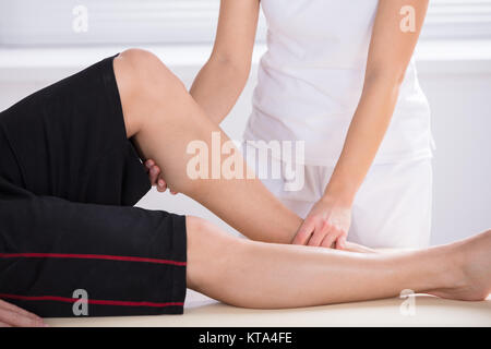 Physiotherapeuten, die Knie Therapie in Klinik Stockfoto