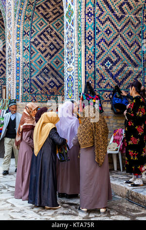 Eine Gruppe von Frauen, die Einkaufsmöglichkeiten für Souvenirs in der Sher Dor Madrassa, der Registan, Samarkand, Usbekistan Stockfoto