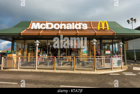 Stürmischen Himmel mit schönen warmen Herbst Sonnenschein, Beleuchtung, einen Antrieb durch das Mcdonald's Restaurant in Stamford, Lincolnshire, England, UK. Stockfoto