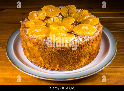 Ein köstliches, frisch gebackene, gewürzt mit Mandeln und geschnittene Orange (clementinen) Kuchen, sitzen auf einer Keramikplatte. England, UK. Stockfoto