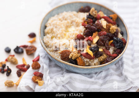 Stahl schneiden Hafer serviert mit getrockneten Früchte und Beeren Stockfoto