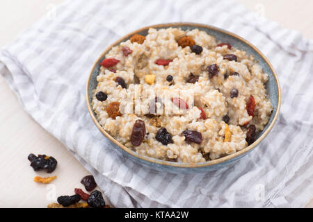 Stahl schneiden Hafer serviert mit getrockneten Früchte und Beeren Stockfoto