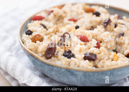 Stahl schneiden Hafer serviert mit getrockneten Früchte und Beeren Stockfoto