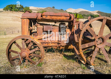 Alten verrosteten Traktor in einem offenen Feld in San Luis Obispo County, Kalifornien sitzen. Stockfoto