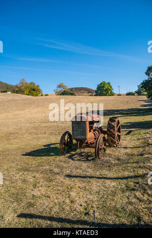 Alten verrosteten Traktor in einem offenen Feld in San Luis Obispo County, Kalifornien sitzen. Stockfoto