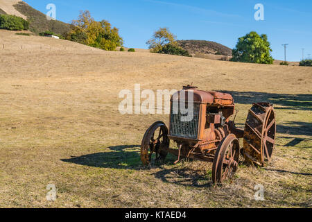 Alten verrosteten Traktor in einem offenen Feld in San Luis Obispo County, Kalifornien sitzen. Stockfoto