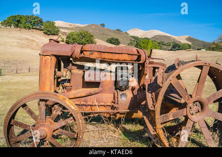 Alten verrosteten Traktor in einem offenen Feld in San Luis Obispo County, Kalifornien sitzen. Stockfoto