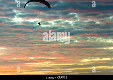 Fortaleza, Brasilien, May 8, 2017: motorisierten Gleitschirm fliegen hoch am Himmel durch den Sonnenuntergang Stockfoto