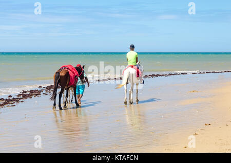 Cumbuco, Brasilien, May 9, 2017: Familie der Pferde reitet für Autovermietung in Cumbuco White Sand Beach in Brasilien Stockfoto