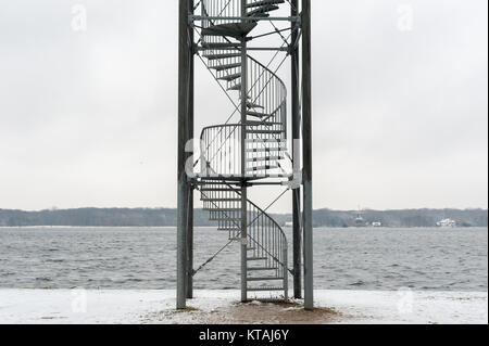 Spiral stahl Treppen unter dem Schnee mit einem See im Hintergrund Stockfoto