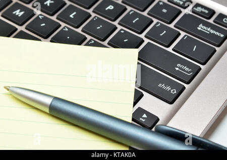 Notizblock und Stift auf der Tastatur, schwarz Stockfoto