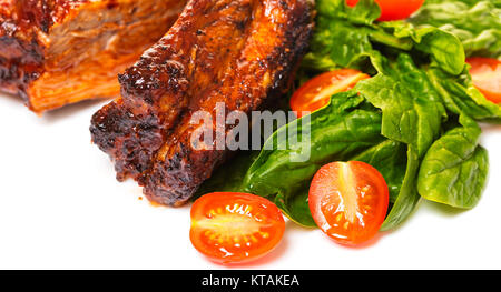 Ribs vom Grill mit Salat auf einem weißen Hintergrund Stockfoto