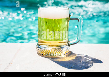 Tasse kaltes Bier auf den Außenpool Stockfoto