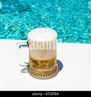 Tasse mit kaltem Licht Bier auf der Außenpool Stockfoto