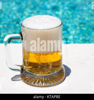 Glas mit kaltem Licht Bier auf der Außenpool Stockfoto