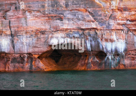 Natürlich geformten Höhlen unter den Mineral sickern Sandsteinfelsen am Lake Superior und die dargestellten Felsen National Lakeshore in Michigan's Upper Peninsula. Stockfoto