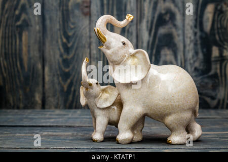 Cute Baby und Mutter Elefanten Figuren auf Blau Holz- Hintergrund Stockfoto