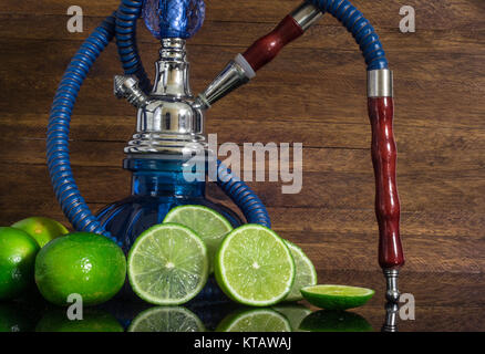 Shisha auf eine reflektierende Fläche, mit Zitronen und Limetten, Holz- Hintergrund Stockfoto