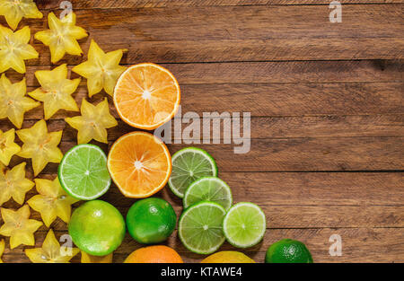 Zitrusfrüchte auf einer hölzernen Hintergrund mit Kopie Raum, Orangen, Zitronen, Limetten und Sternfrucht Stockfoto