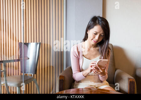 Frau mit Handy in Coffee Shop Stockfoto