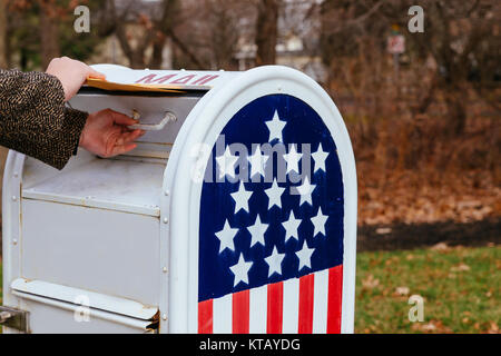 In der Nähe der Person Hand Briefe in der Mailbox amerikanische Flagge Stockfoto