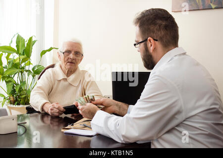 Private Arztpraxis. Der Arzt nimmt Geld für eine Arztpraxis. Stockfoto