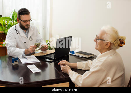 Private Arztpraxis. Der Arzt nimmt Geld für eine Arztpraxis. Stockfoto