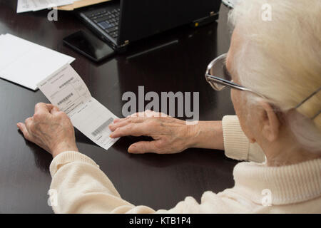Der Patient, eine alte Frau, die ein Rezept liest. Stockfoto
