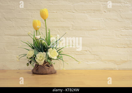 Künstliche Blumen dekoriert auf hölzernen Tisch Stockfoto