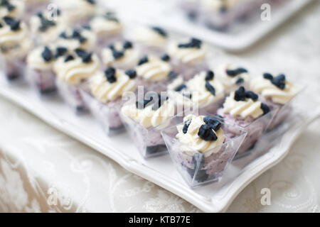 Tabelle mit viel Kuchen und Muffins in Kartons. Stockfoto