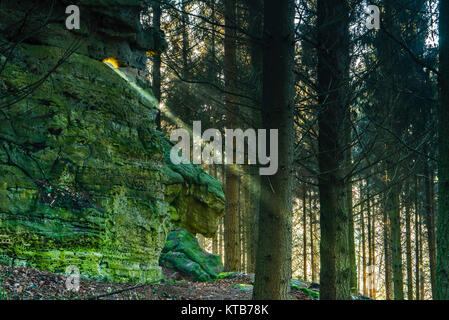 Das Sonnenlicht fällt märchenhaft durch ein Felsenloch im Wald Stockfoto