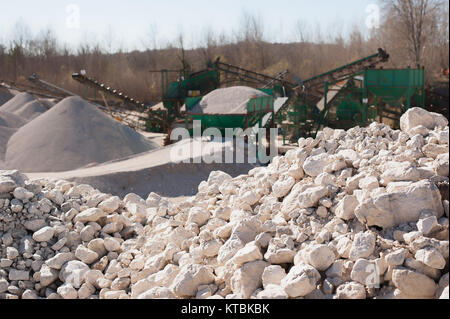 Haufen Kies - Rock. Auf Hintergrund Maschinerie der Steinbruch verwischt. Stockfoto